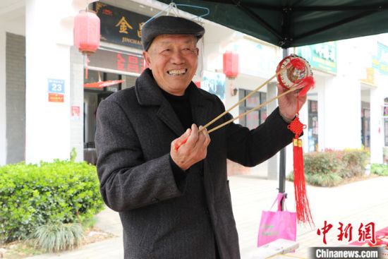 3月5日,安徽小岗村"大包干"带头人严金昌展示当地特产——凤阳花鼓.